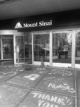 View of the front doors of Mount Sinai hospital with chalk drawings on the ground expressing &quot;Thank You&quot; and gratitude to the frontline workers